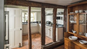 A kitchen with exposed wooden beams, a herringbone floor, and a wooden cabinet with dishes. - Lovely 3-bed House in West Malling, Kent (West Malling)