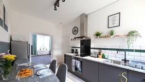 Una cocina moderna con gabinetes grises, una estufa negra y una ventana con cortinas.