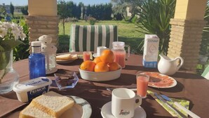 Une table dressée pour le petit-déjeuner, avec de la nourriture et une vue sur la verdure.