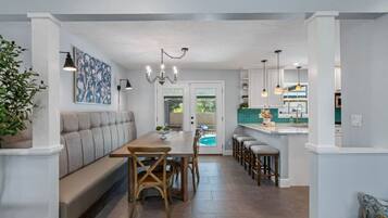 A spacious kitchen with a dining area, a built-in bench, and a view of the backyard.