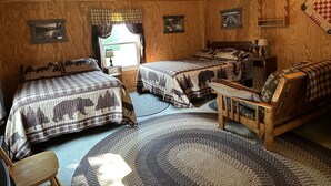 A cozy room with two beds, a wooden ceiling, a window with curtains, and a ceiling fan. - Marzullo's Mountaintop Cabin (Brookville)