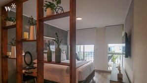 Un dormitorio moderno con una cama grande, estanterías de madera con plantas, una mesita de noche y vistas al exterior.