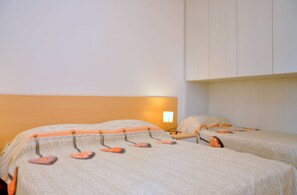 Ein Hotelzimmer mit zwei Betten, einem Nachttisch und einer Wandlampe.