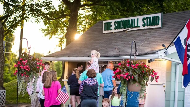 A small building labeled "The Snowball Stand" with a sign above the entrance.