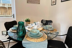 Enjoy meals in this dining area with a glass table, woven placemat, and comfortable seating for four.