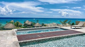 Zona de piscina con vista al océano y cielo despejado.