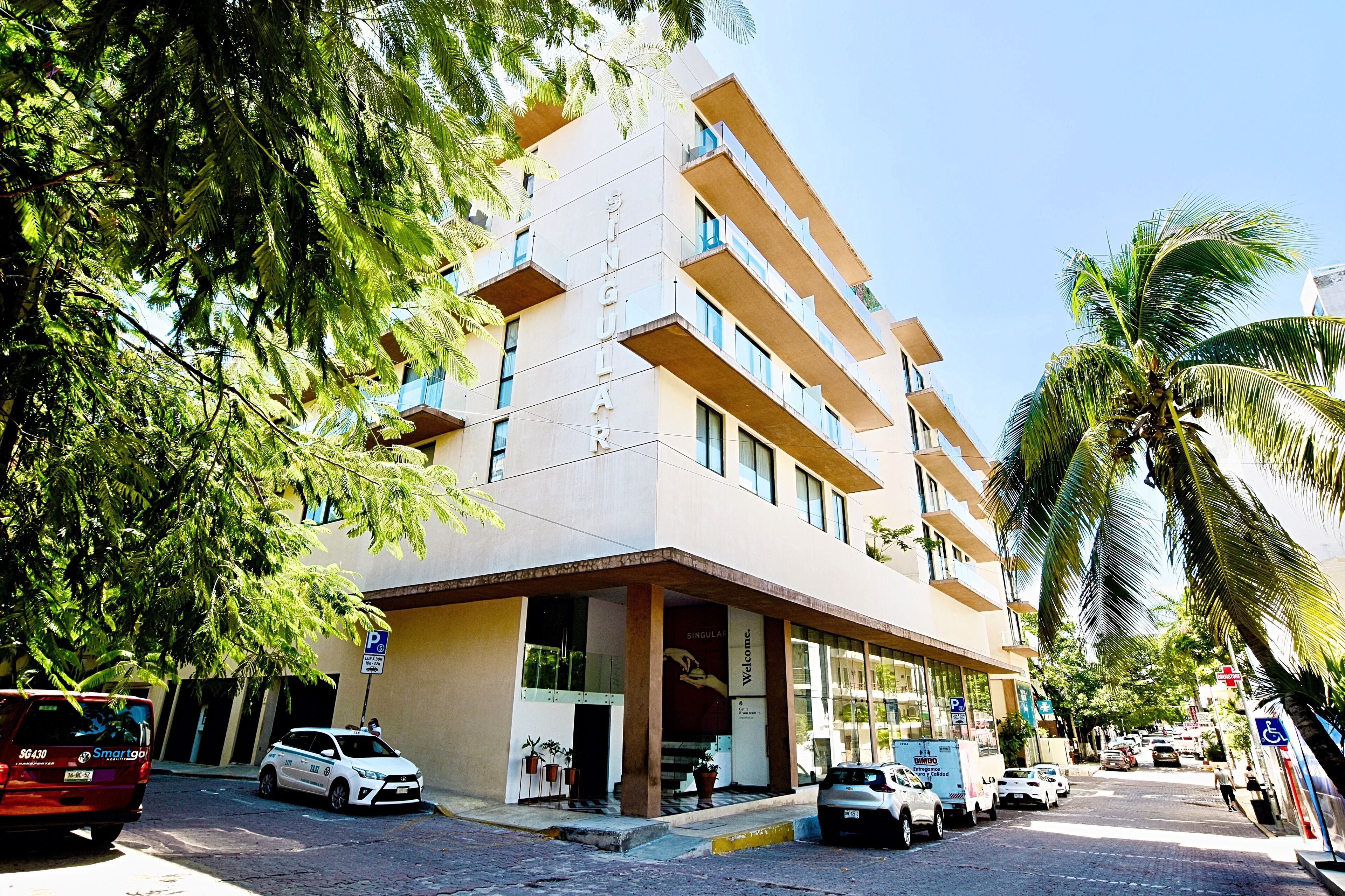Ein mehrstöckiges Hotel mit modernem Design, mit Balkonen und einem markanten Eingang.
