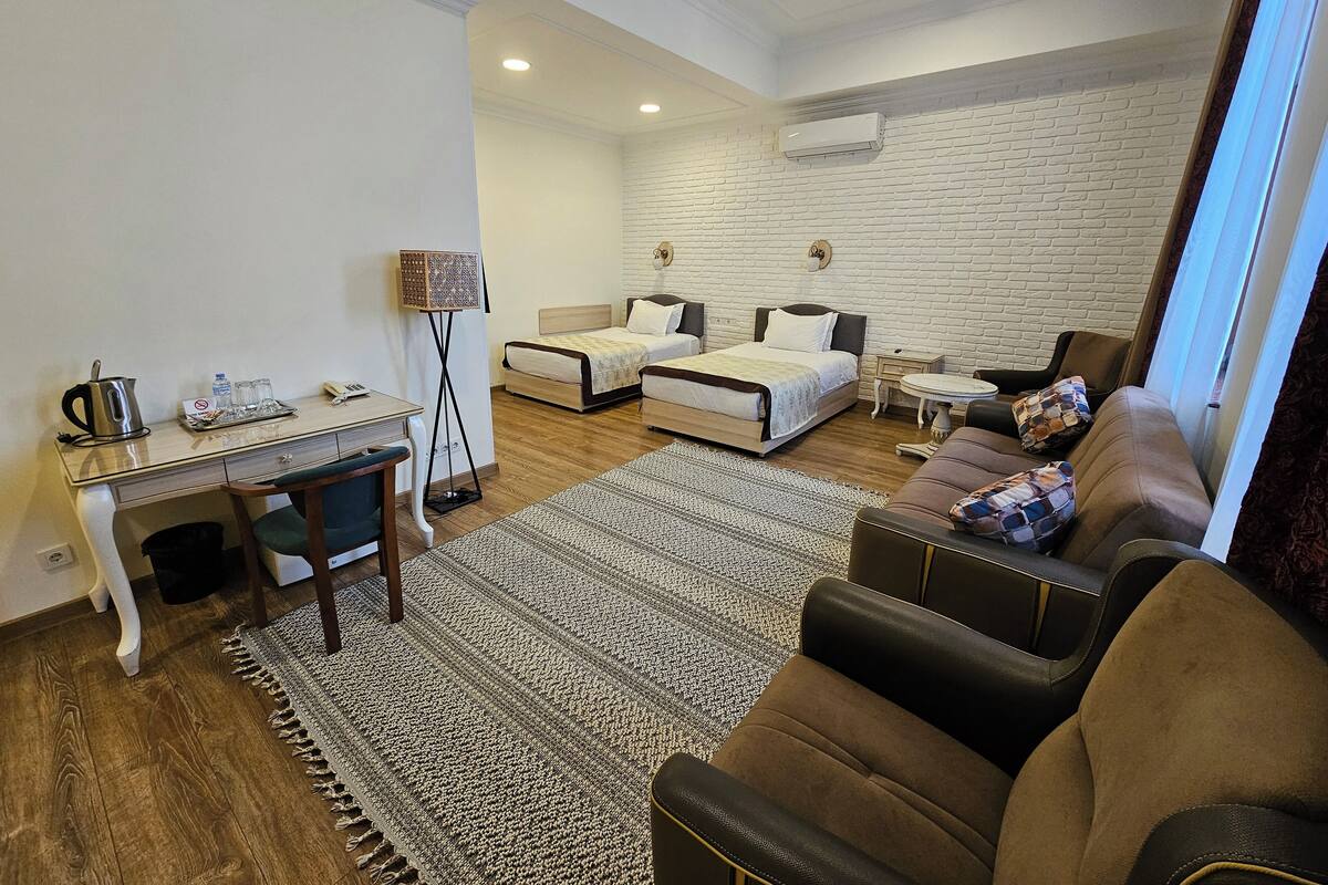 Ein modernes Hotelzimmer mit Bett, Sofa, Schreibtisch und Couchtisch.