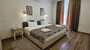 Une chambre d’hôtel avec un grand lit, une petite table de chevet, un climatiseur fixé au mur et une fenêtre avec des rideaux.