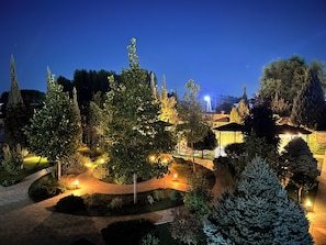 A landscaped garden with pathways, trees, and a gazebo.
