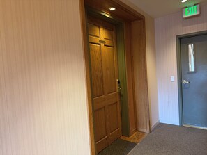 A wooden door with a green frame, a carpeted floor, and an EXIT sign above it. -  Modern Mountain Retreat - Ski-in-out - Heated Pool and Hot Tub (Steamboat Springs)