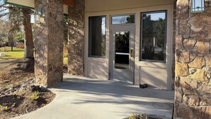 A stone building with a covered entrance, large windows, and a caution sign. -  Modern Mountain Retreat - Ski-in-out - Heated Pool and Hot Tub (Steamboat Springs)
