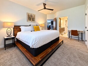 A modern bedroom with a large bed, bedside lamps, a ceiling fan, and a desk with a chair. -  Modern Mountain Retreat - Ski-in-out - Heated Pool and Hot Tub (Steamboat Springs)