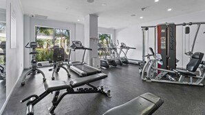 Une salle de sport équipée de tapis de course, de vélos elliptiques et de matériel de musculation.