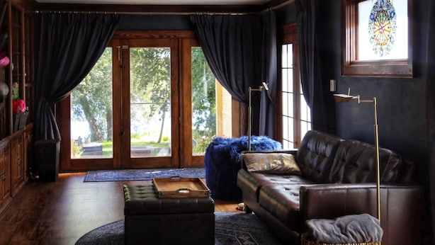 A cozy living room with a leather sofa, a round coffee table, and a blue rug. - Riverfront Getaway (Two Rivers)