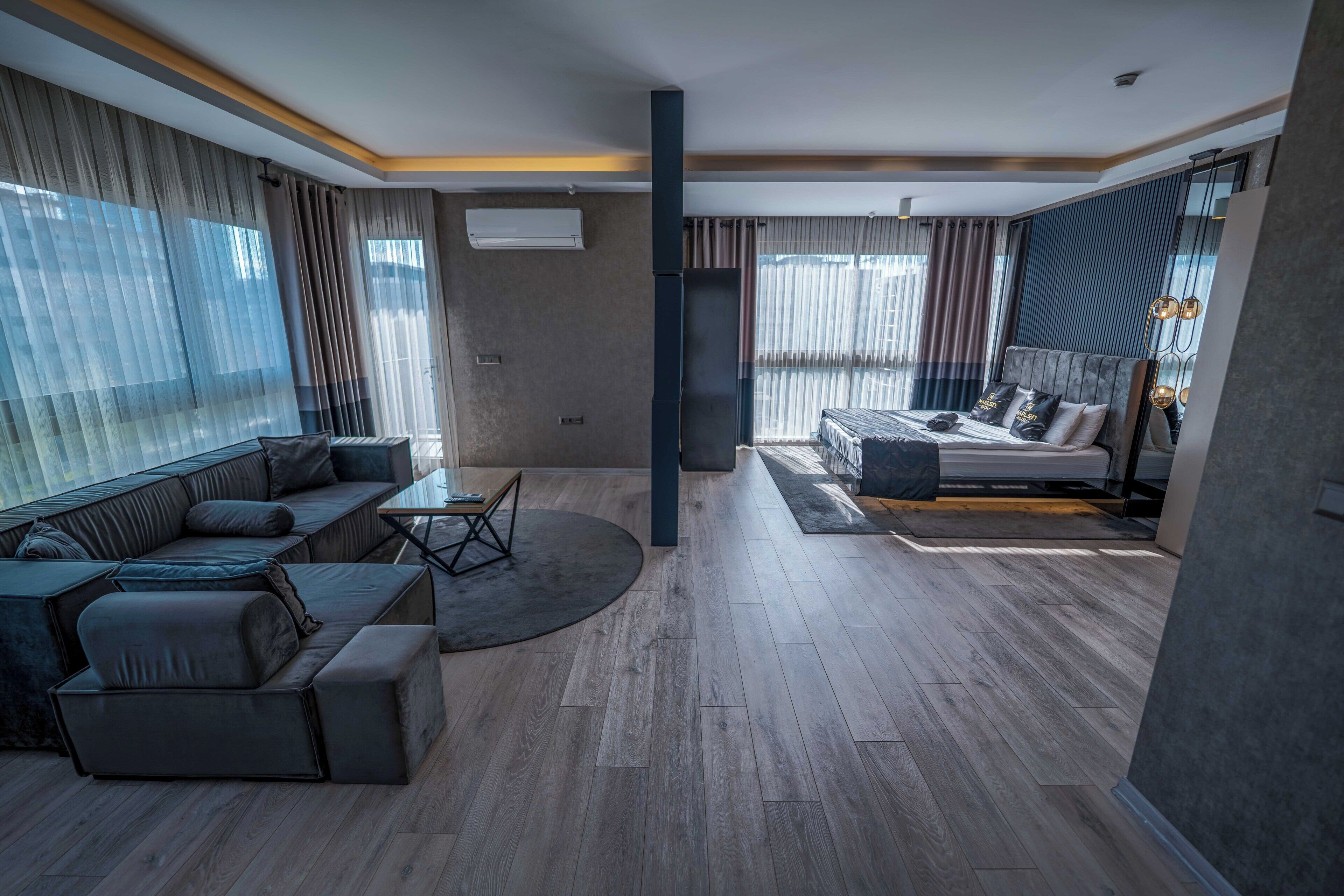 Una sala moderna con sofá, una mesa de centro y una cama con cabecera.