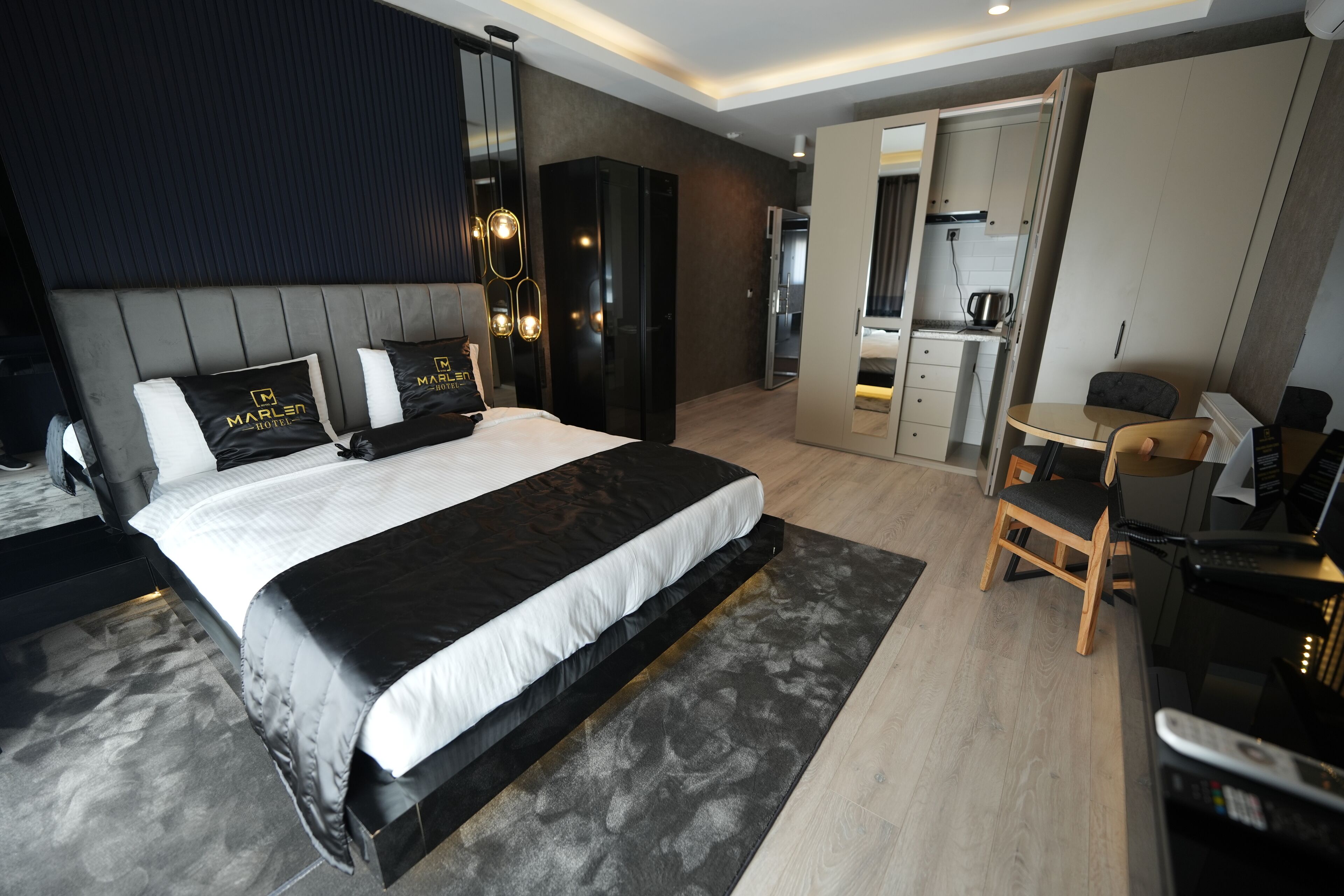 Une chambre d’hôtel moderne dotée d’un grand lit, d’un bureau et d’une kitchenette.