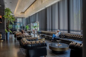 A spacious lobby with leather seating, large windows, and a high ceiling with a chandelier. - Marlen Hotel Bayrakli (Izmir)
