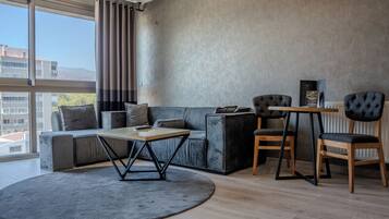 A modern living room with a sofa, a coffee table, and two chairs.
