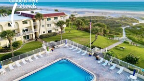 Un condo à deux niveaux avec piscine, vue sur la plage et un patio clos.
