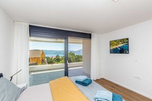A bedroom with a bed, a view of the sea, and a painting on the wall. - Villa DEI TRAMONTI with private pool (Linardici)