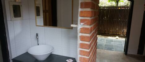 A bathroom with a white sink, a mirror, and a tiled floor.