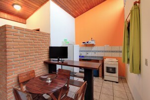 Een keuken met een bakstenen muur, een houten tafel en een fornuis.
