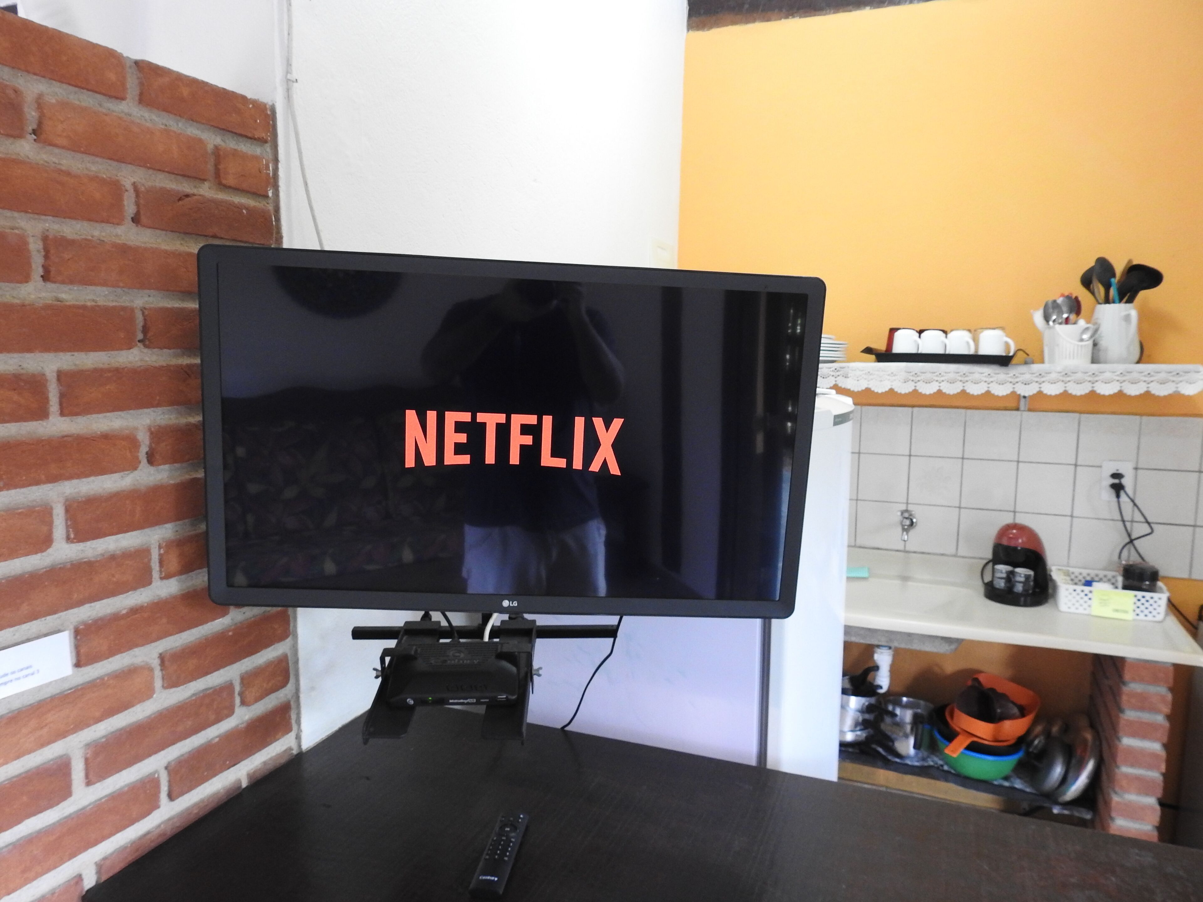 A television mounted on a wall with a visible Netflix logo.