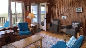 Une pièce chaleureuse avec un décor intérieur en bois, un canapé bleu, une table en bois et une chaise.