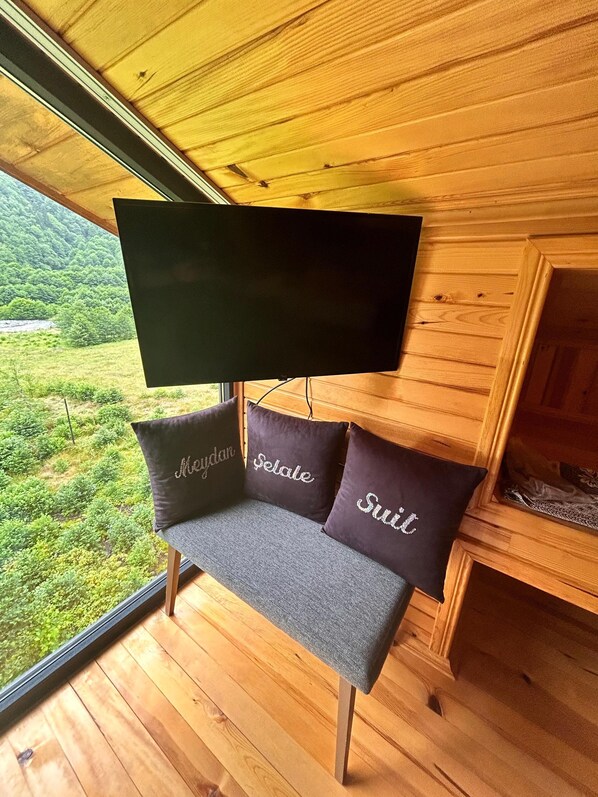 A wooden cabin with a bench and three cushions with names.