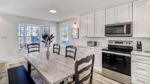 A modern kitchen with white cabinets, a stainless steel stove, and a microwave. - Golf Cart & Pool included! Pet-Friendly Retreat <1 mile from Beach (Santa Rosa Beach)