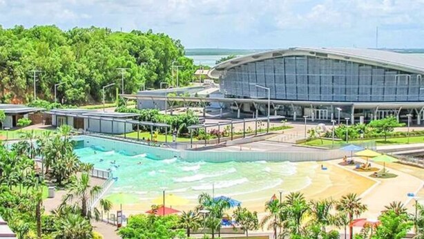 A modern building with a large pool and a beach area. - Zenhouse Stylish: Lawn ~ Workspace ~ OutdoorDining (Muirhead)