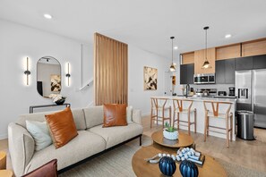 A modern apartment with a living room, kitchen, and dining area. - Bright 3BR Townhouse w/ Loft, Near Disney, Pool & Gym Access (Kissimmee)