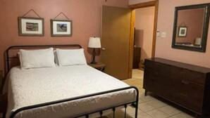 A bedroom with a bed, a dresser, a ceiling fan, and two framed pictures on the wall. - Peek-a-Moo Apt w/patio, paddle boating (Raymondville)