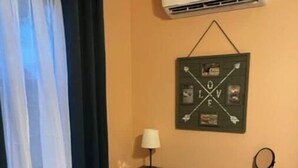 A small room with a desk, chair, air conditioning unit, and a wall decoration. - Peek-a-Moo Apt w/patio, paddle boating (Raymondville)