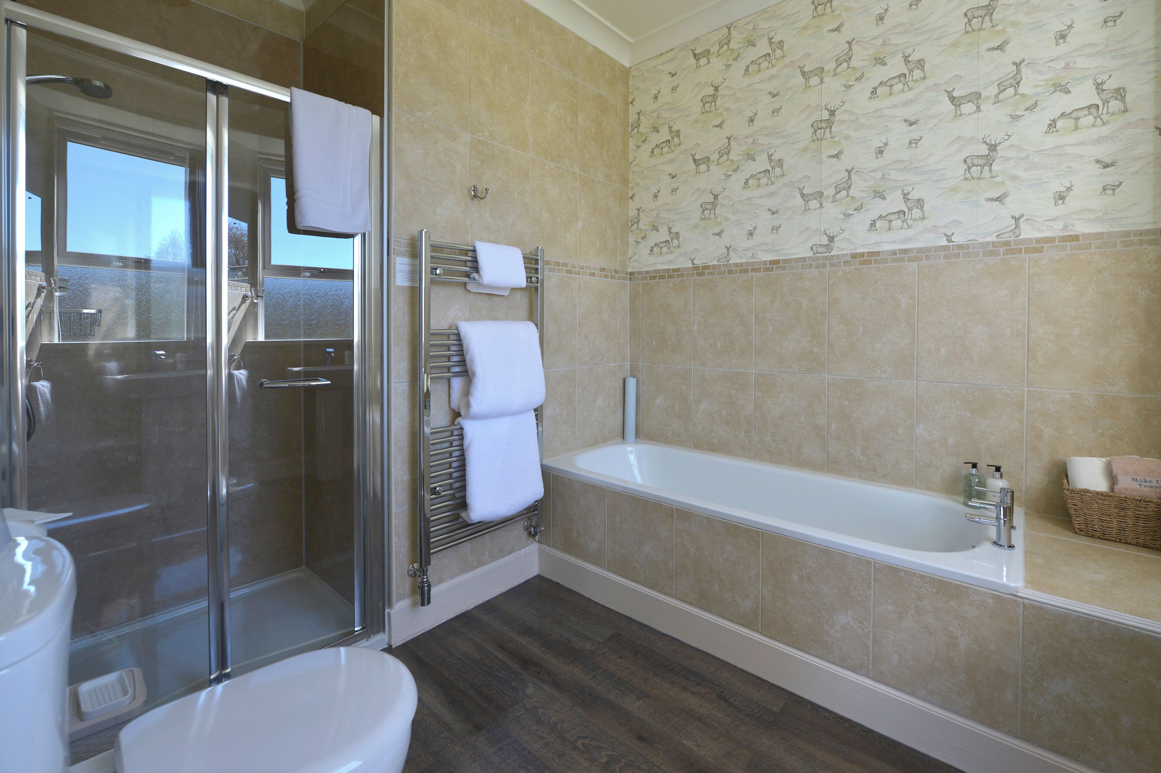 Un baño con cabina de ducha de vidrio, bañera y retrete.