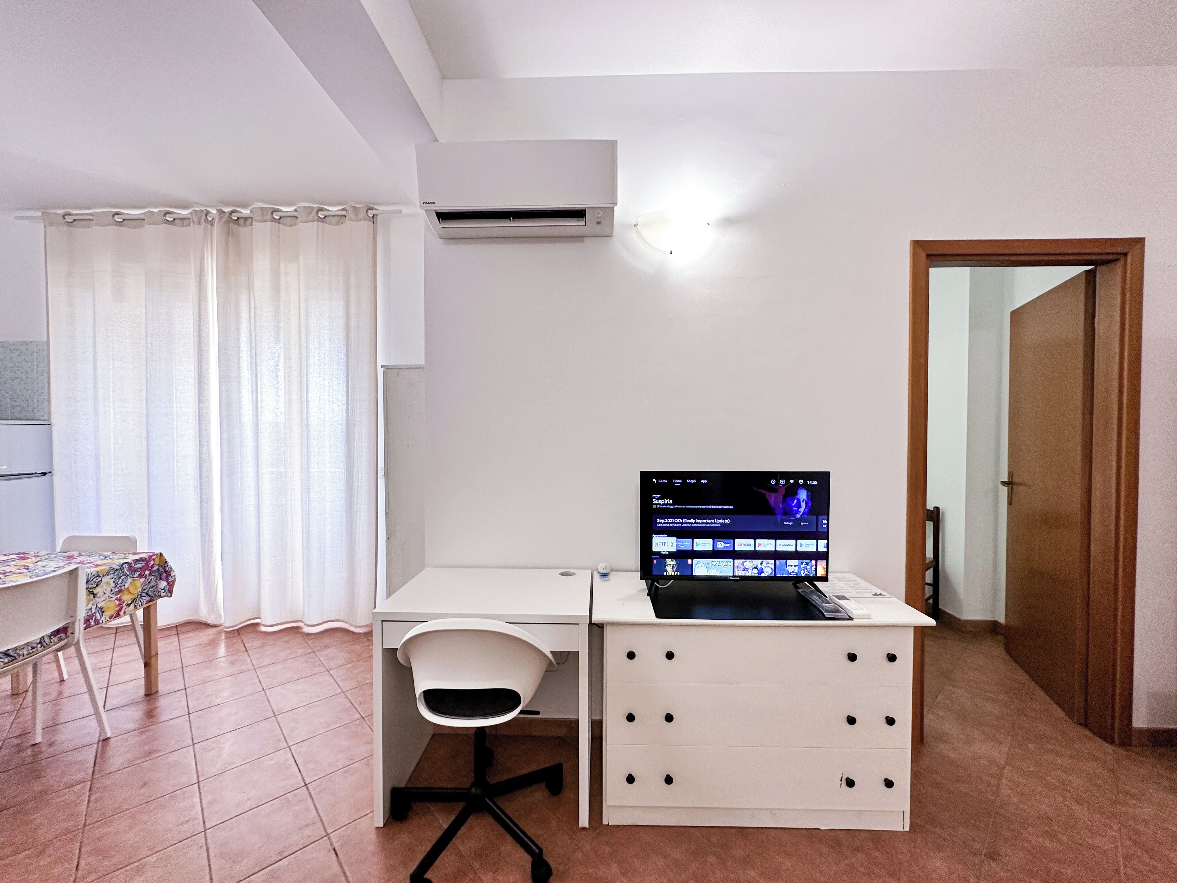 A small, clean room with a desk, chair, and a laptop.