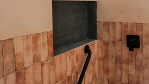 A bathroom with a tiled floor, a black shelf, a black towel rack, and a black wall-mounted device. - Manglito Manila, a 3 Minutos del Malecón de La Paz (La Paz)