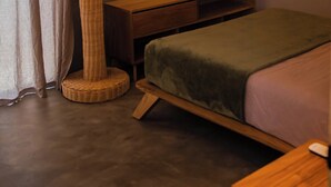 A bedroom with a bed, a wooden nightstand, a wall-mounted shelf, a cactus-shaped floor lamp, and a window with curtains. - Manglito Manila, a 3 Minutos del Malecón de La Paz (La Paz)