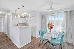 Enjoy a bright and airy space with a central island, pendant lights, and a dining area with a glass-top table.