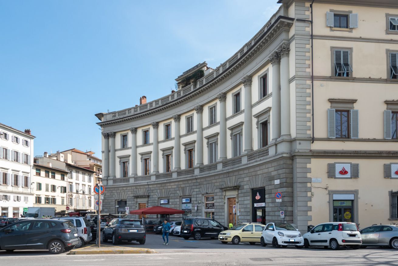 Um edifício histórico com arquitetura clássica, fachada curva e entrada central.