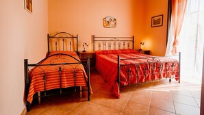 Un dormitorio con dos camas, techo de madera y ventana con cortinas.