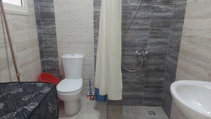 Un bagno con WC, doccia e vasca da bagno.