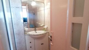 Un baño con lavamanos, espejo y mueble.