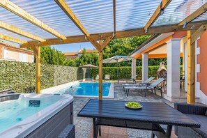 A covered outdoor swimming pool area with lounge chairs and a hot tub. - Vila Lotus 13k by Istrabook (Pula)