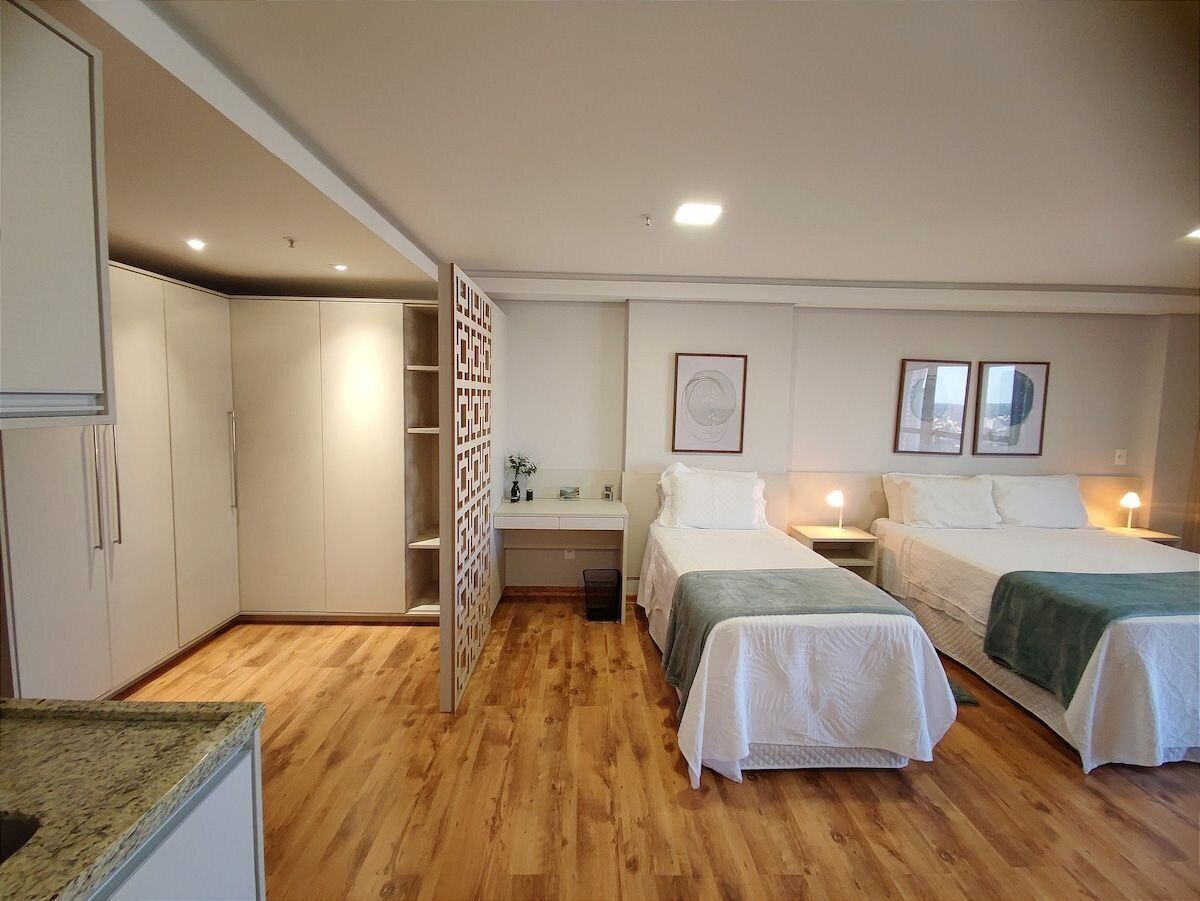 A room with two beds, a desk, and a wardrobe.
