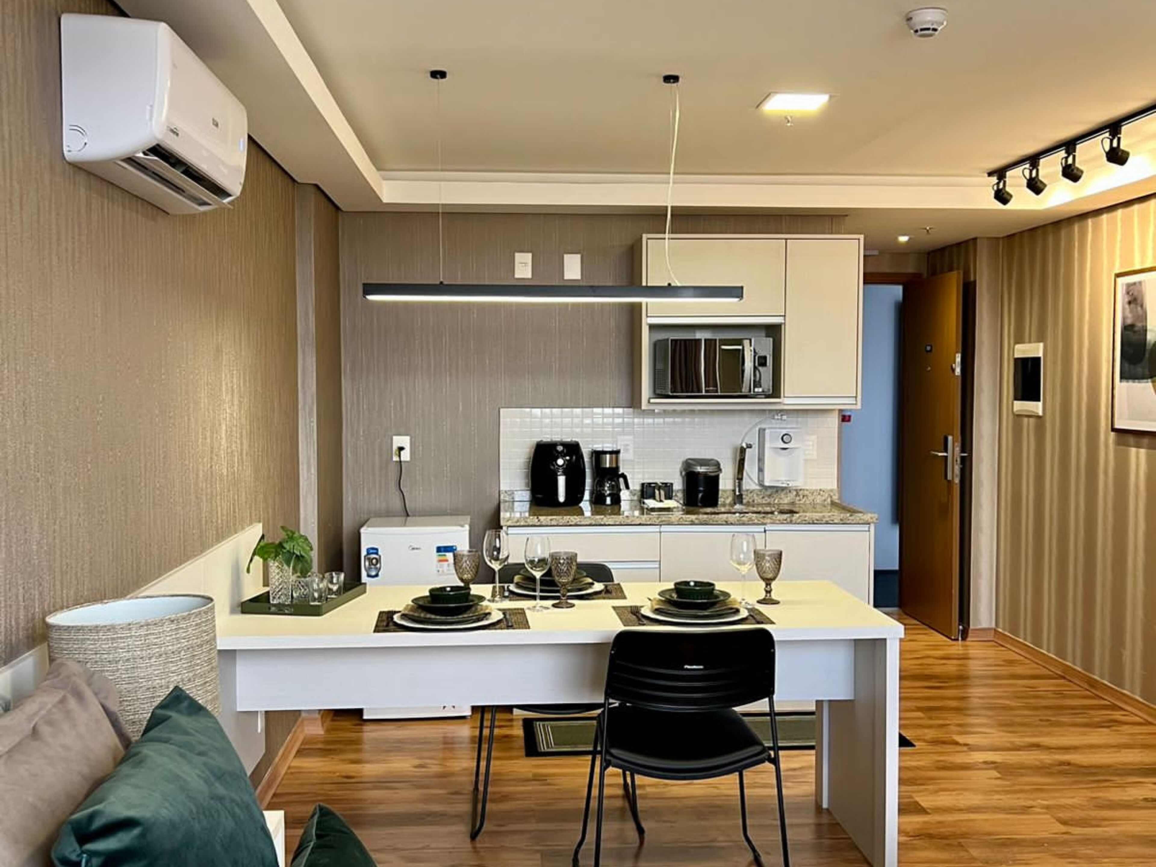 Una cocina moderna con una isla central, armarios blancos y un microondas.