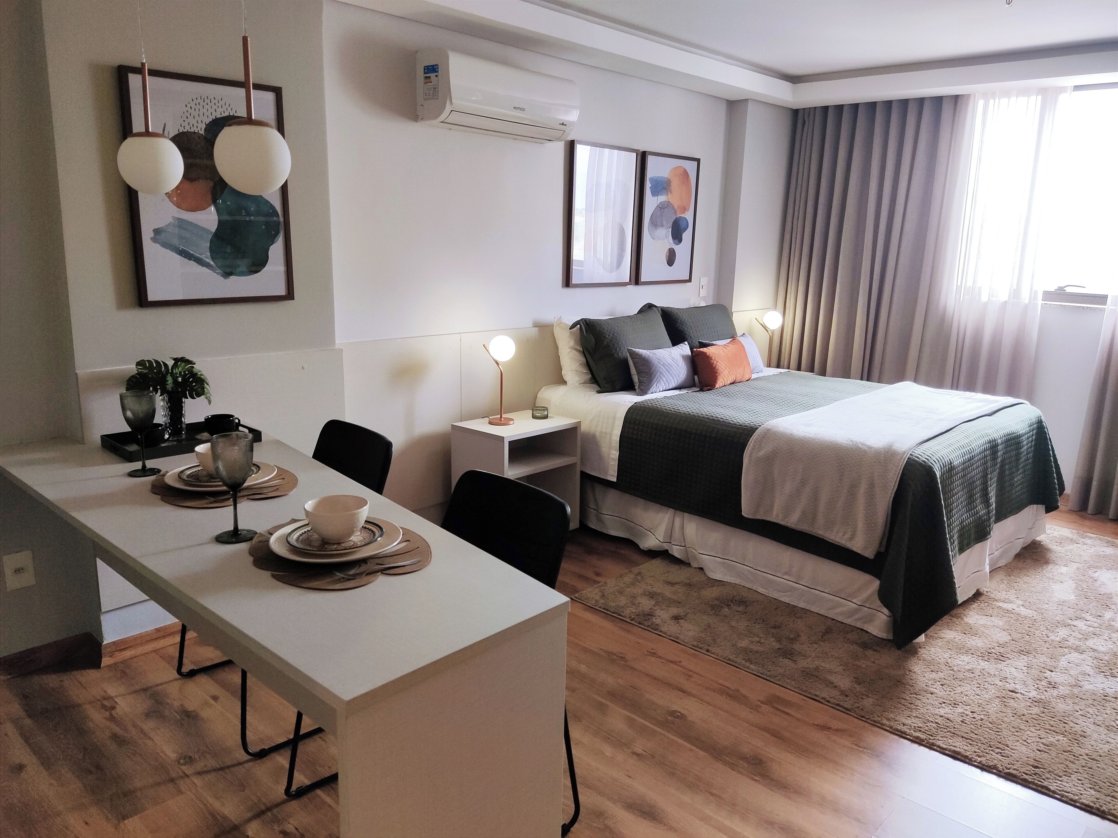 Una habitación de hotel moderna con cama, mesita de noche, escritorio y sillas.