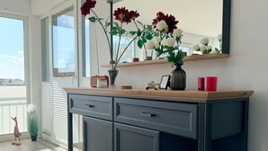 Una cocina moderna con un mueble oscuro, una encimera de madera y un florero con flores.