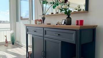 Eine moderne Küche mit einem dunklen Schrank, einer Holz Arbeitsplatte und einer Vase mit Blumen.